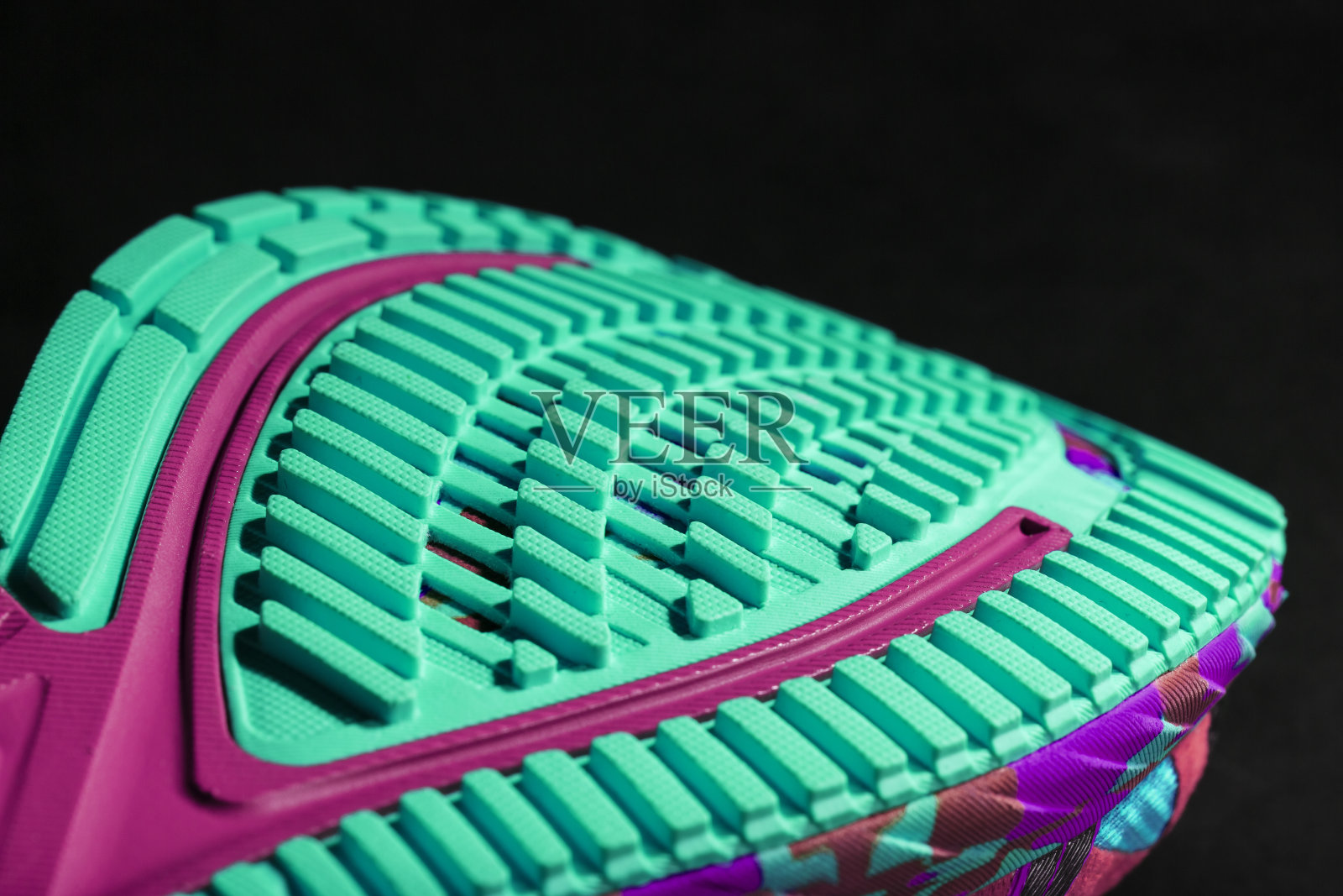 有纹理的蓝色鞋底的运动跑鞋在黑色的背景。照片摄影图片