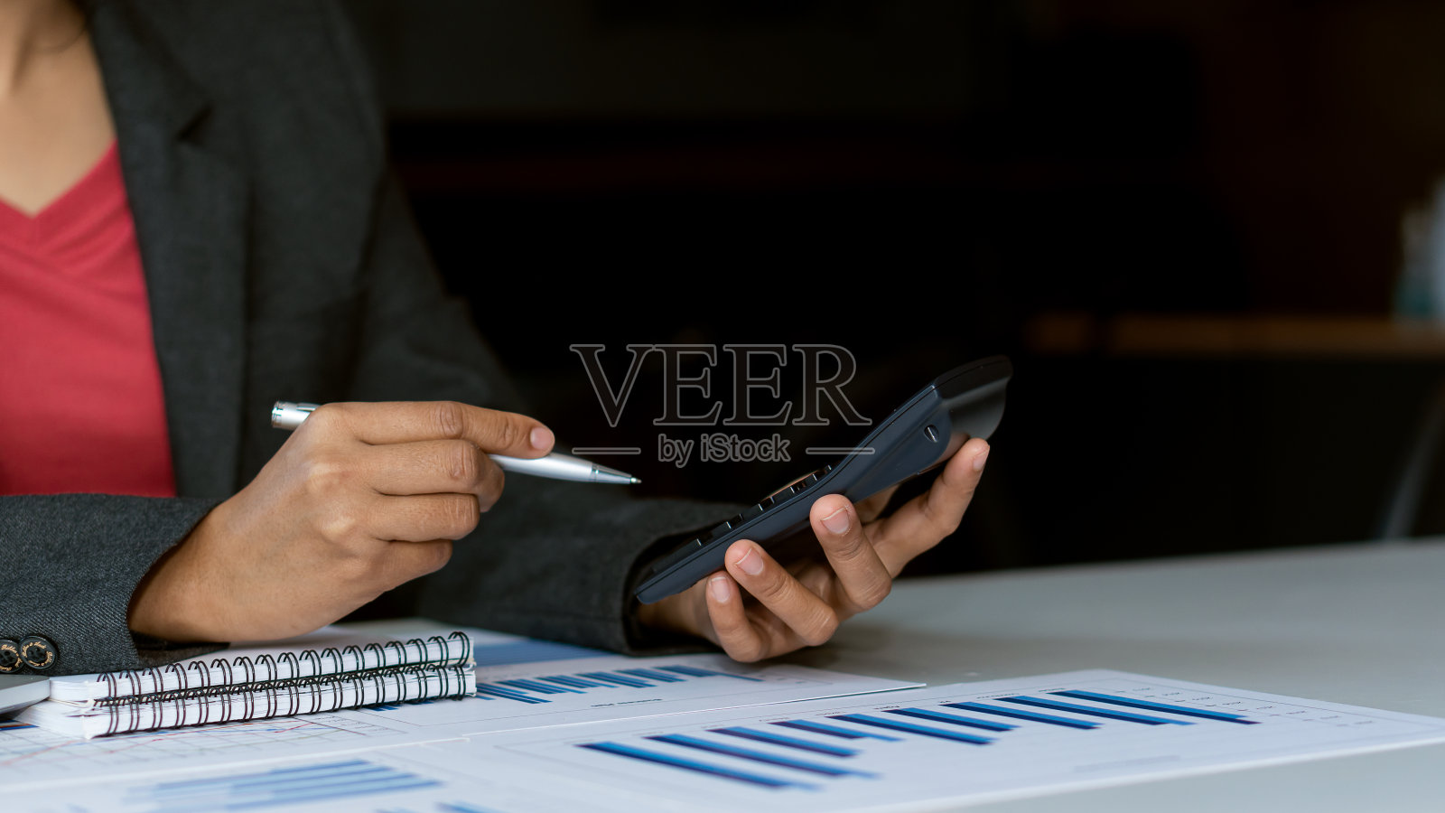 会计在工作时使用智能手机，在工作场所分析业务报告。财务规划与会计概念照片摄影图片