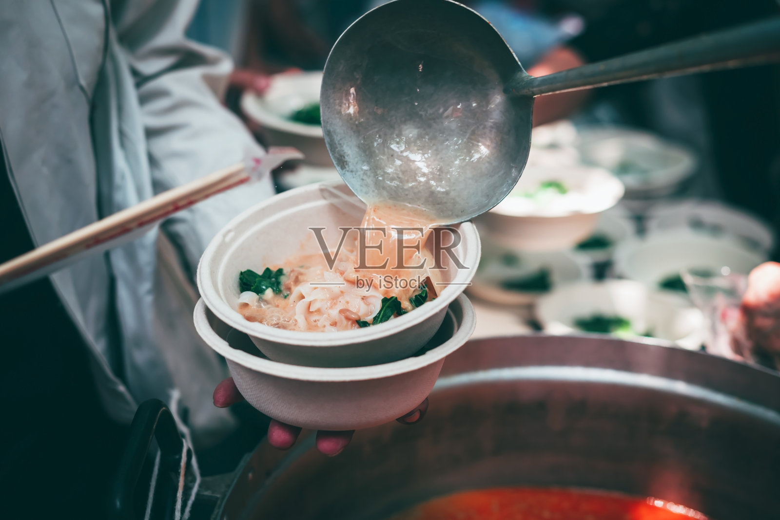 志愿者给无家可归的穷人分发美味的食物:饥饿问题的概念照片摄影图片