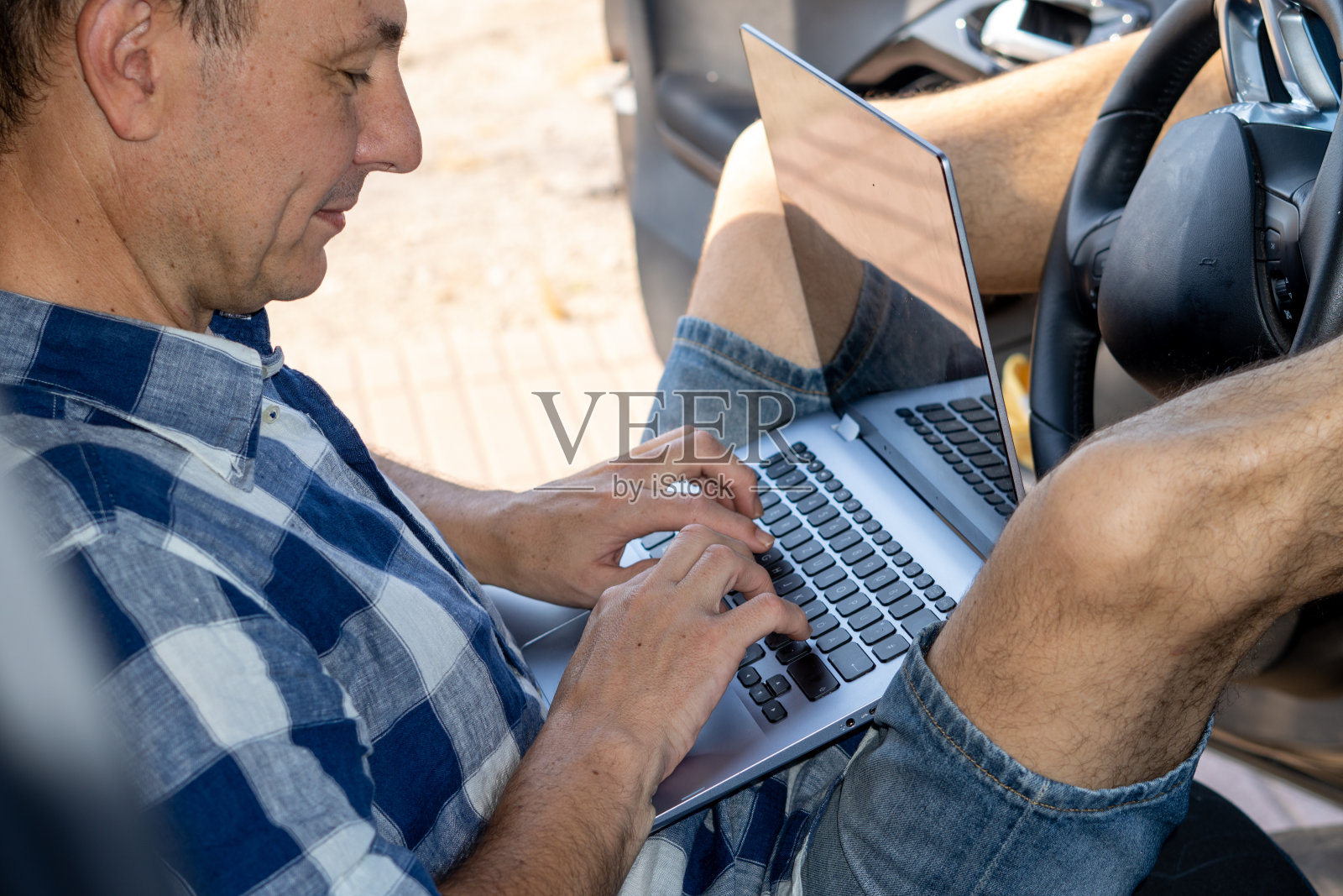 一个在车里用笔记本电脑工作的人照片摄影图片