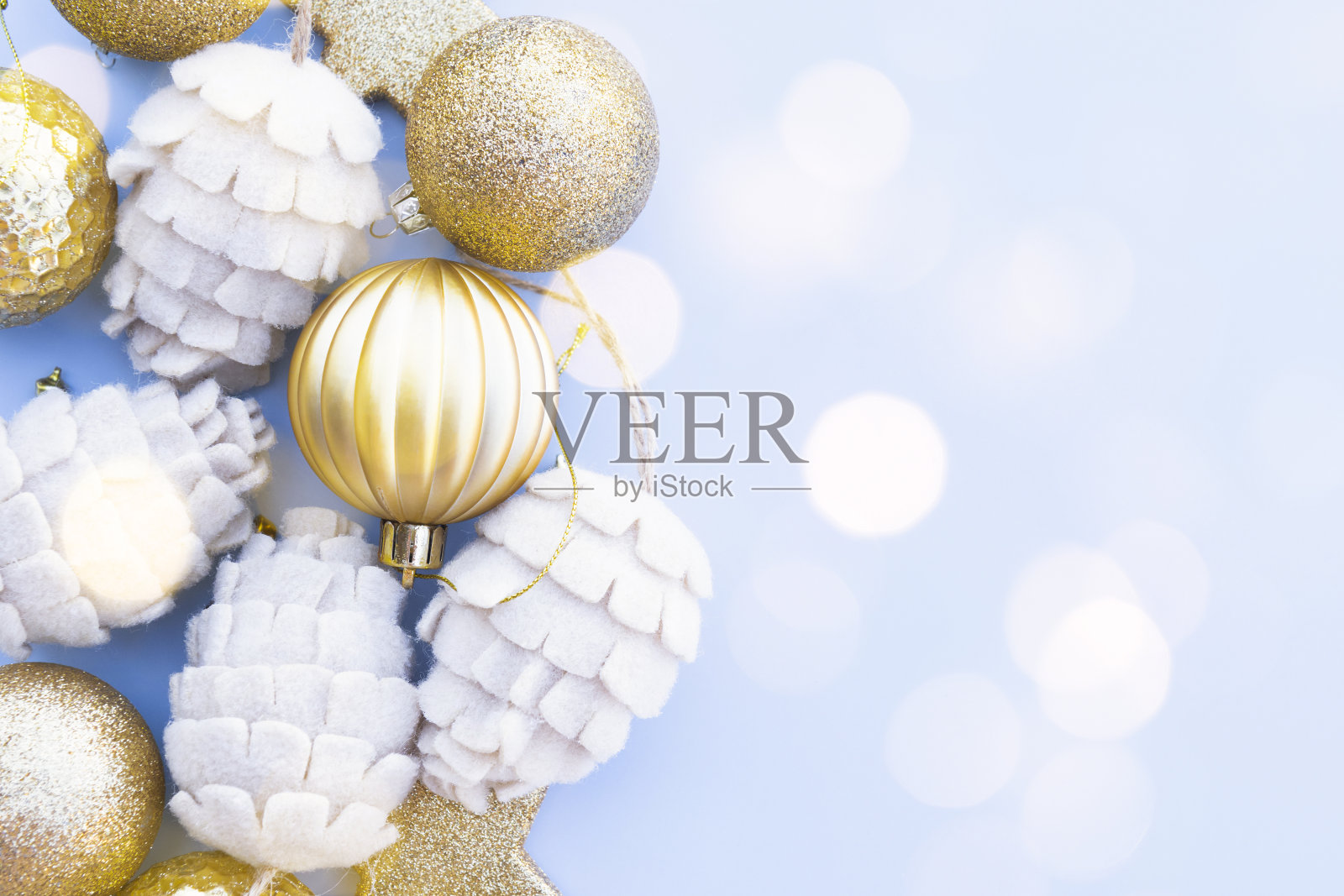 美丽的金色和米色圣诞小玩意儿在蓝色的背景照片摄影图片