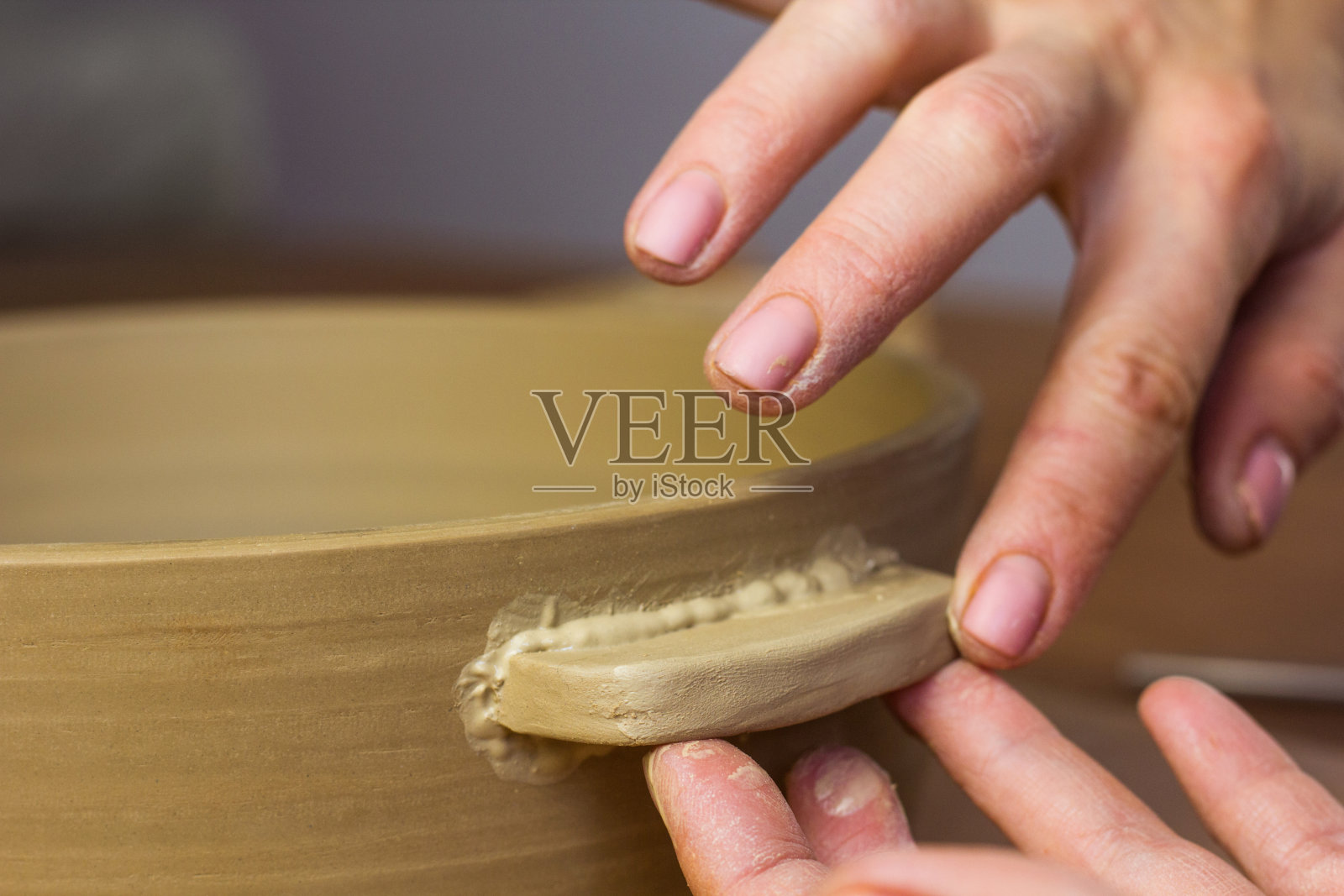 陶艺课上，女陶艺家在锅上安装把手。陶艺工作室的陶工车间照片摄影图片