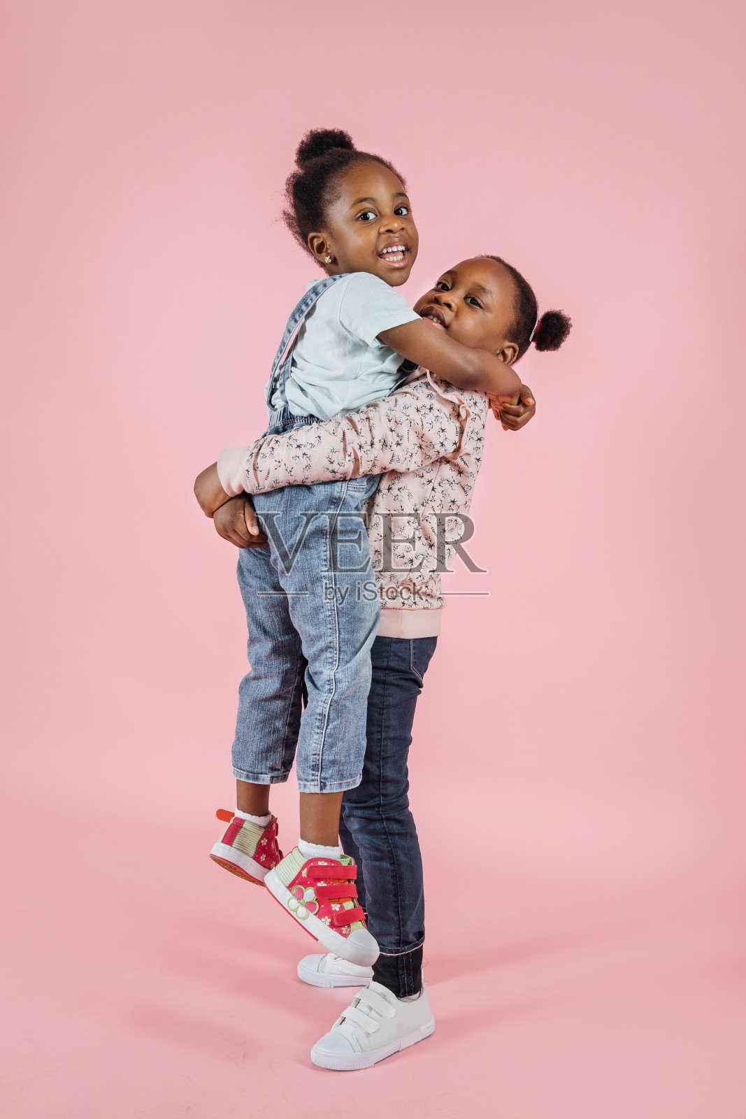 有趣的两个小非洲可爱的女孩姐妹，有乐趣在一起，摆着相机照片摄影图片