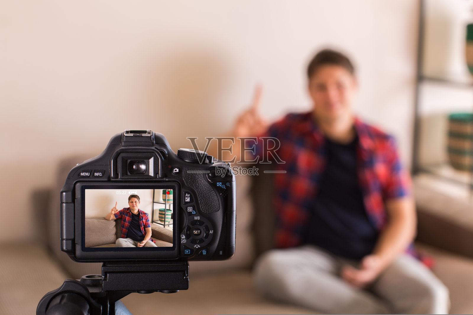 坐在沙发上录制社交媒体视频的视频博主照片摄影图片