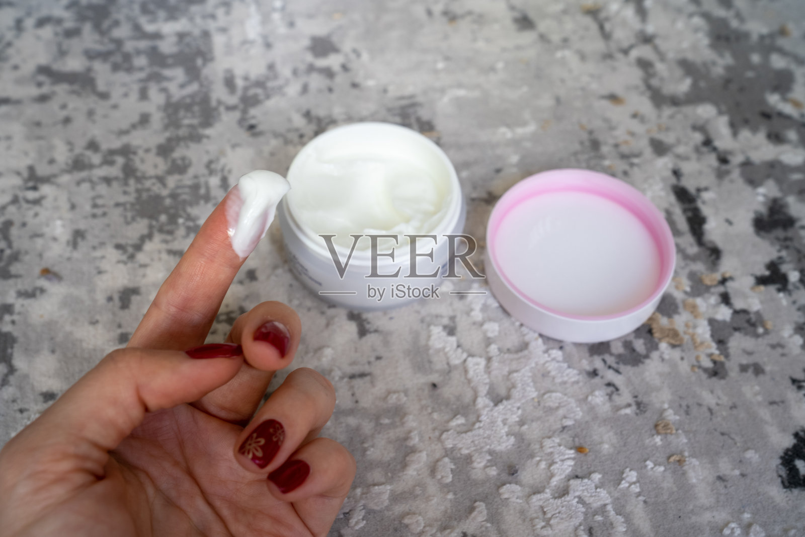 女子敷面霜，手用白色护理霜，面霜塑料坛子，自我护理理念照片摄影图片