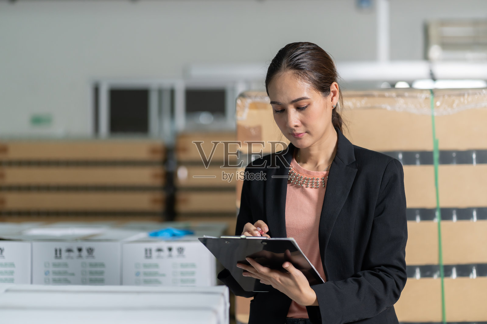 年轻女工的肖像写检查在仓库工作。检验质量控制照片摄影图片