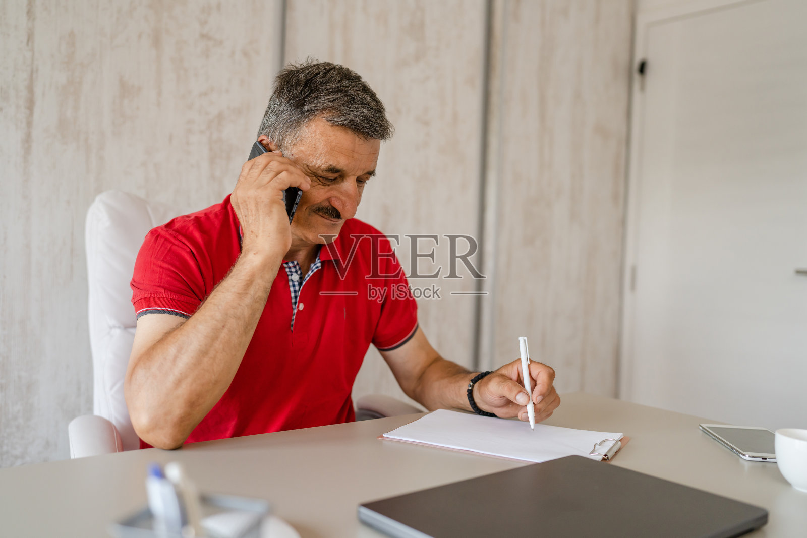 一名男性企业家活跃的白人男性打电话聊天，坐在办公桌前工作，办公室经理和小企业真人拷贝空间照片摄影图片