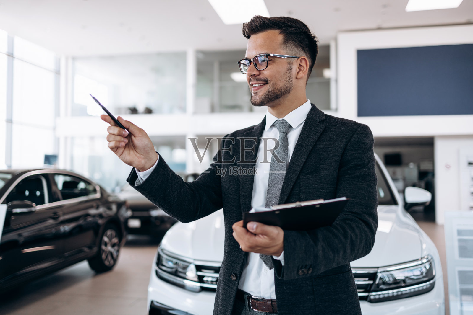 汽车经销商站在陈列室和摆姿势照片摄影图片