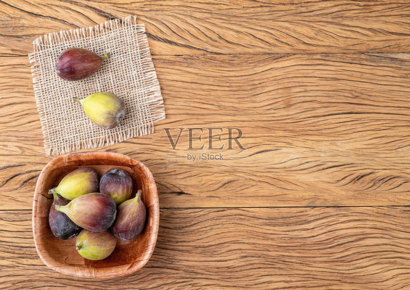 有复印空间的木桌上方的碗里放着无花果照片摄影图片