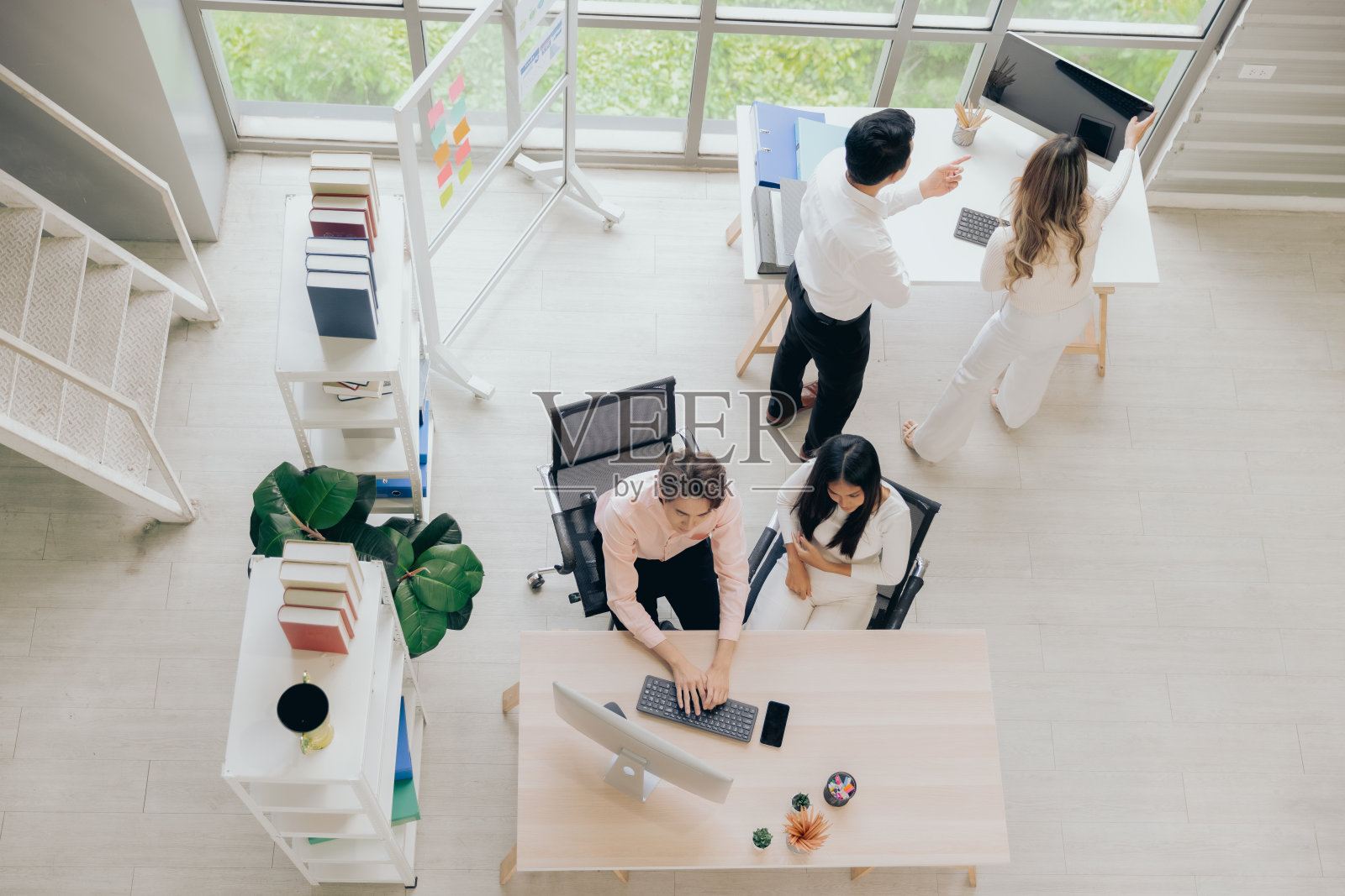 年轻的同事男女组同事在工作空间随意办公，回到办公室的概念，俯视图照片摄影图片