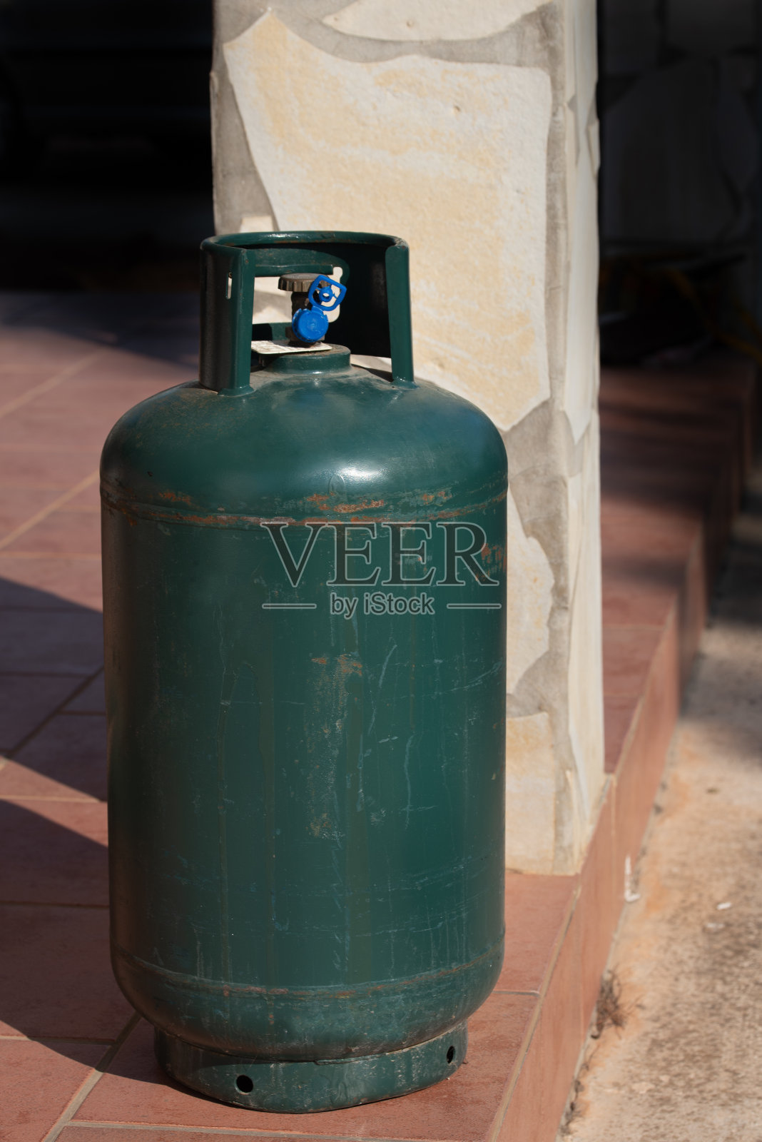 意大利的一个露台上放着一个绿色的金属气瓶。这是一个储物瓶，需要重新加满照片摄影图片