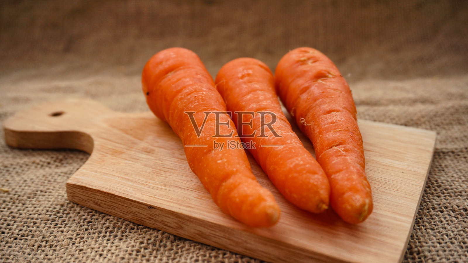 把新鲜胡萝卜平铺在砧板上照片摄影图片