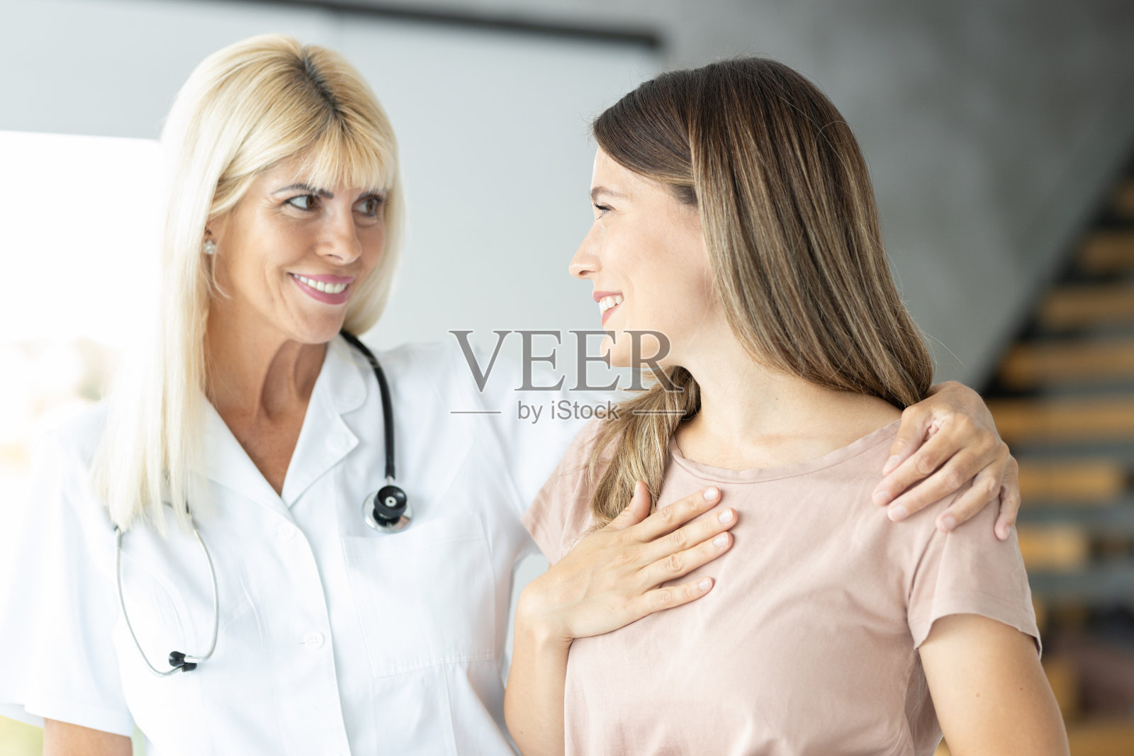 金发女医生正在和病人交谈照片摄影图片