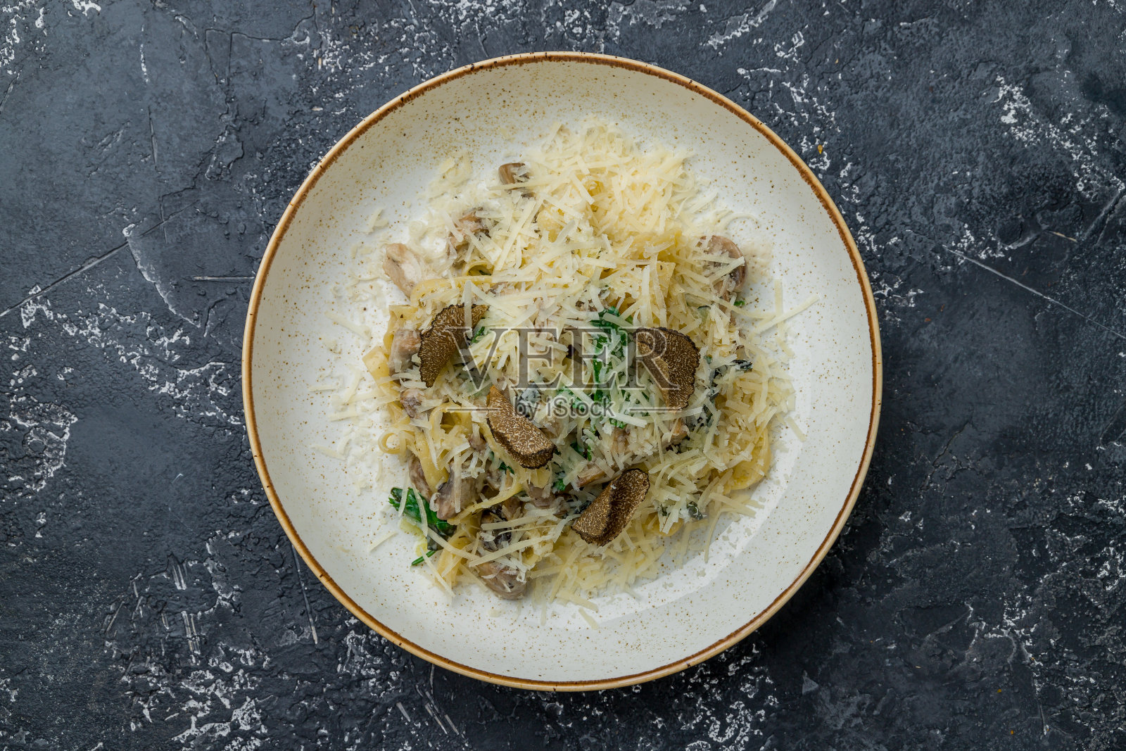 意大利面与牛肝菌和松露与菠菜在黑色的石头桌子的顶部视图照片摄影图片
