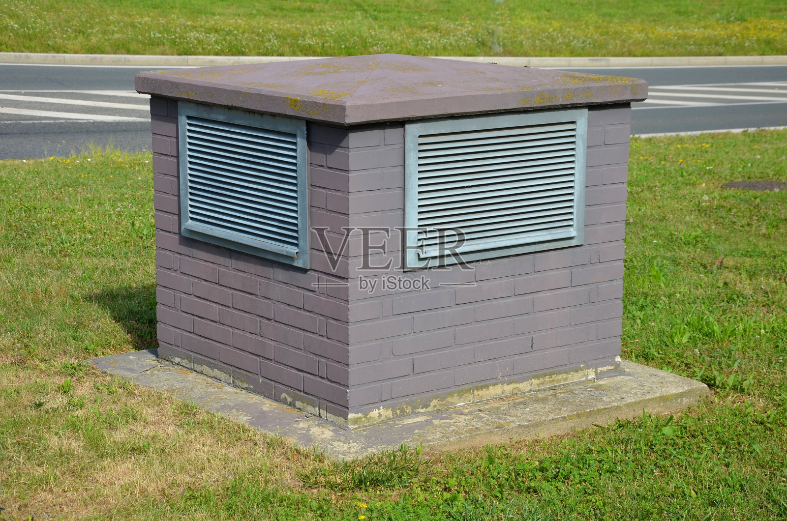 方形通风格栅箱。某住宅建筑、能源被动式建筑、地铁隧道通风的空气回收管道采用板条覆盖。热泵，砖，草坪照片摄影图片