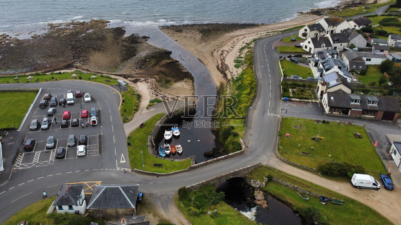 一个停车场和背景是大海的小房子的鸟瞰图照片摄影图片