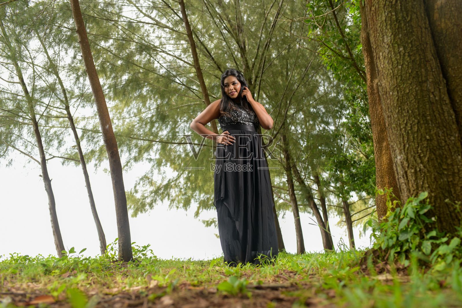 微笑的南亚妇女在一个黑色长裙照片摄影图片