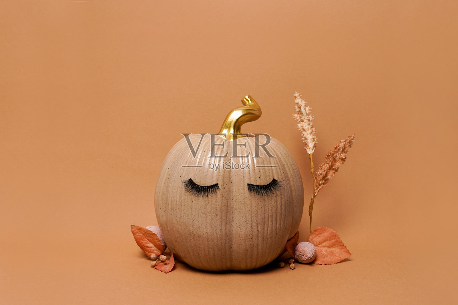 南瓜假睫毛和秋天的树叶在橙色的背景。秋天，秋天，万圣节的概念。本空间照片摄影图片