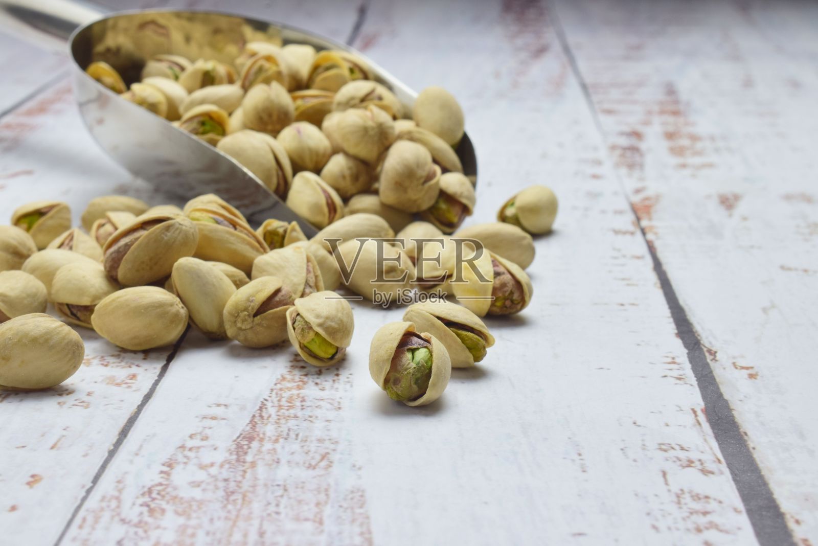 质朴的木桌上放着开心果照片摄影图片