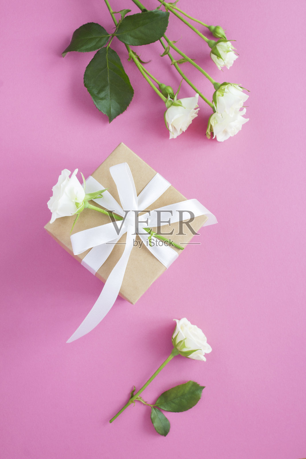 礼品盒和白色玫瑰在粉红色的背景。前视图。照片摄影图片