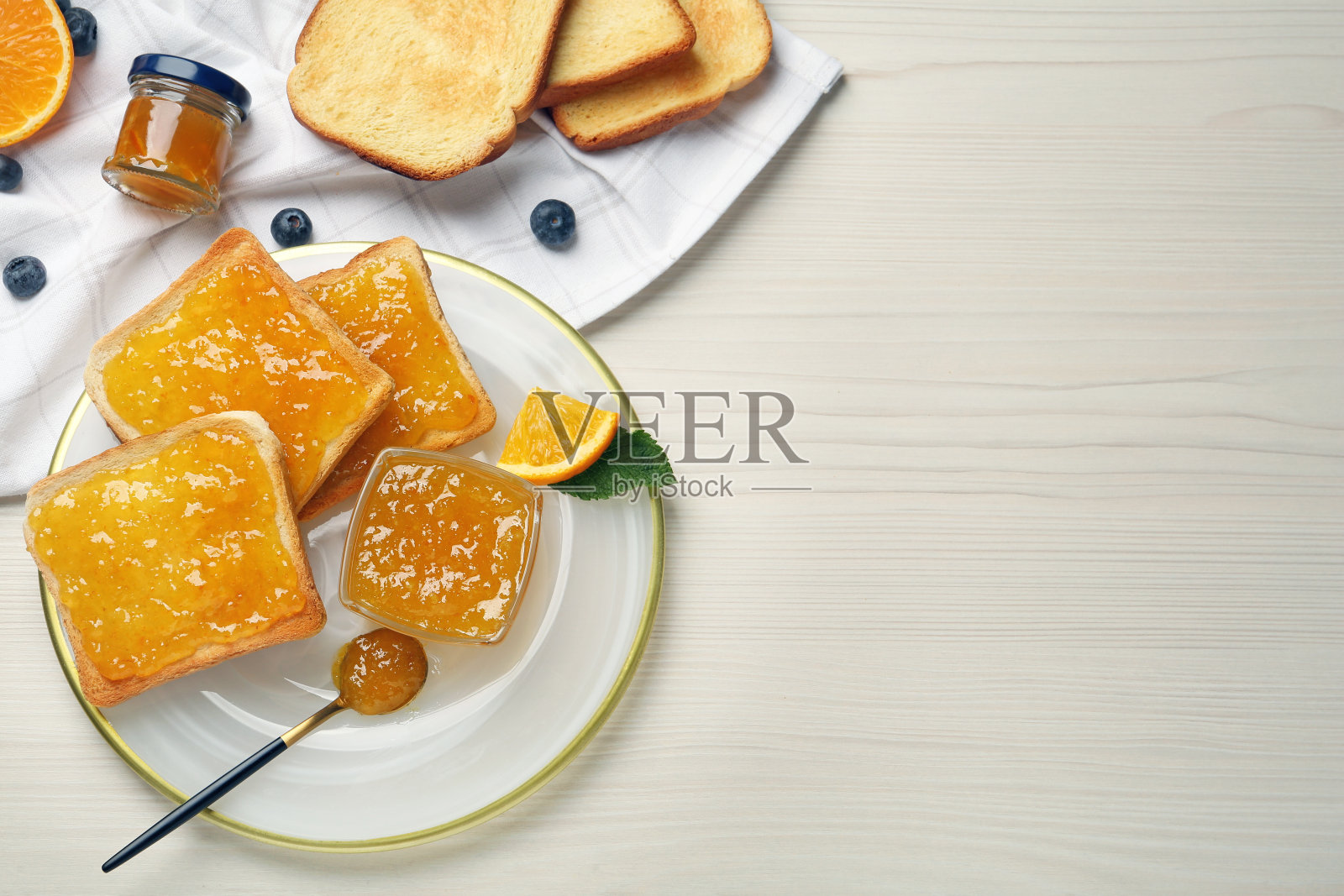 美味的果酱烤面包摆在白色的木桌上，平铺着。空间的文本照片摄影图片