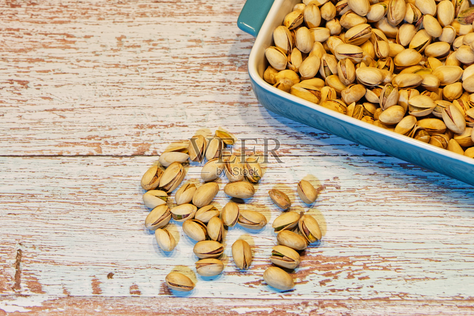 白色的蓝色碗与盐开心果壳在白色复古木桌上一些装饰照片摄影图片