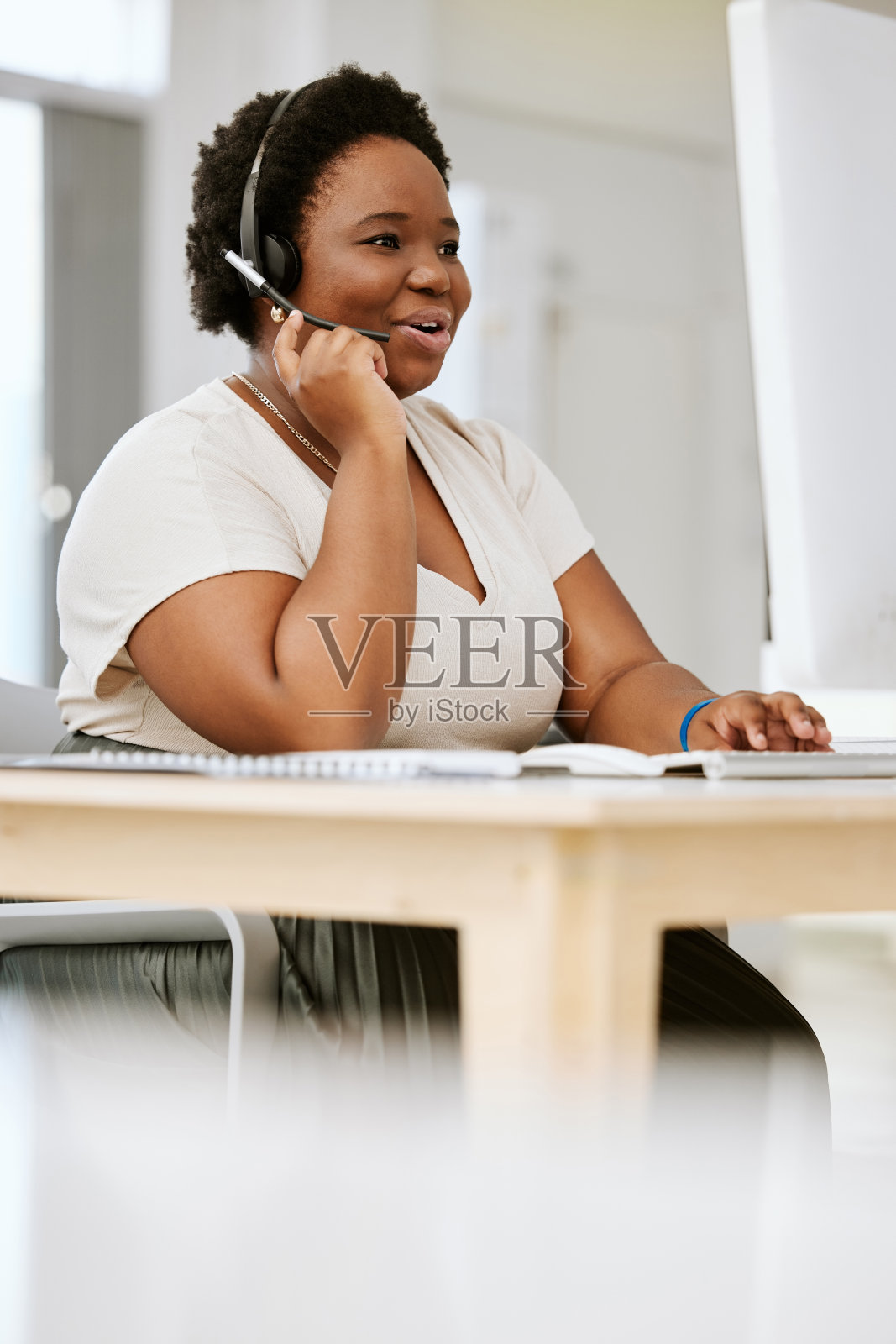 快乐，微笑和说话的呼叫中心代理工作在计算机，网络在线和帮助互联网。友善的黑人女性客服代理在工作中策划和讨论照片摄影图片