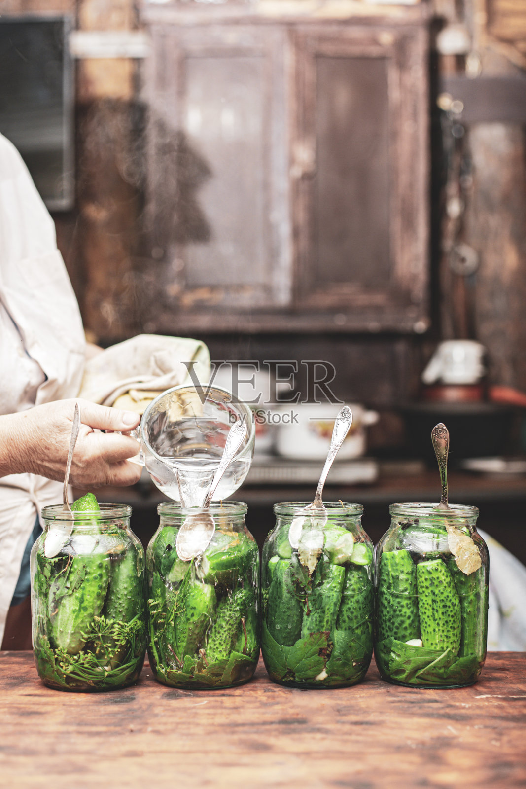 外婆在准备泡菜以避免饥饿，背景模糊不清照片摄影图片