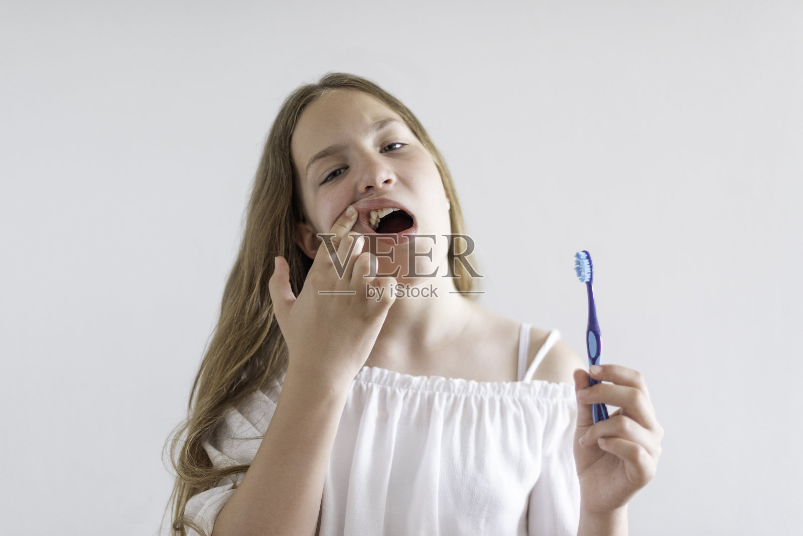 一个十几岁的女孩正在刷牙照片摄影图片