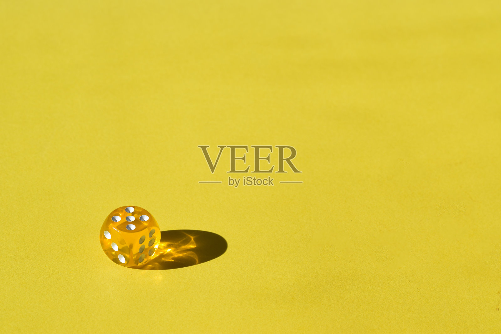 黄色透明塑料立方体在黄色背景与文字空间。夏天的桌游照片摄影图片