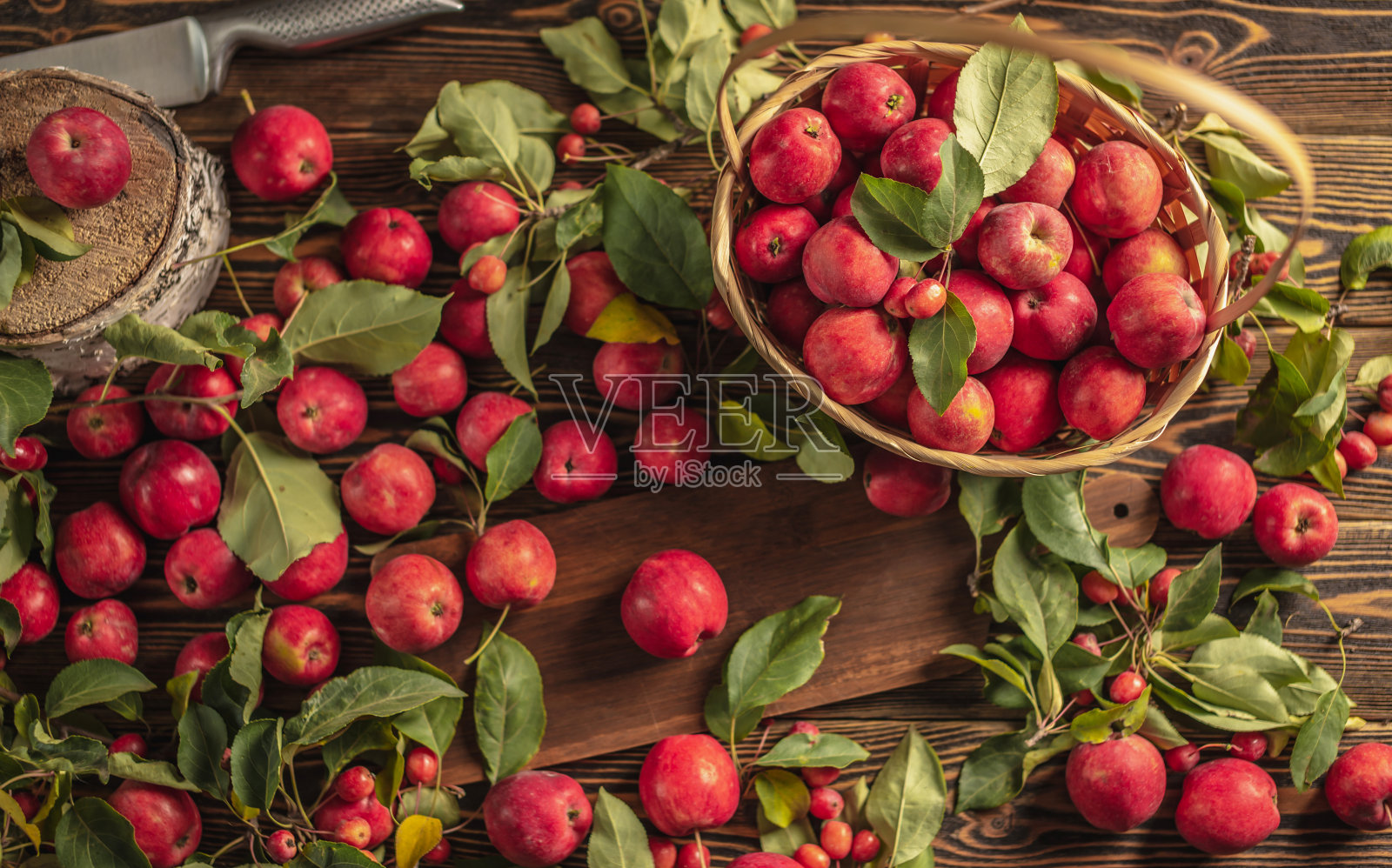 开胃的红苹果和绿叶放在木桌和篮子里。秋高气爽，收获新鲜照片摄影图片