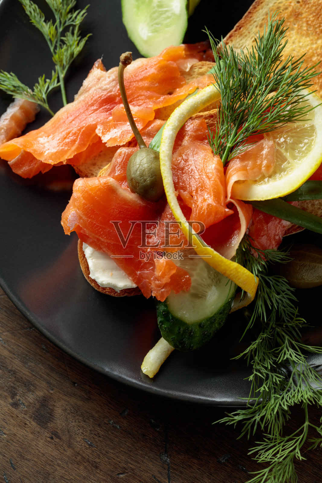 三明治加三文鱼和蔬菜。照片摄影图片