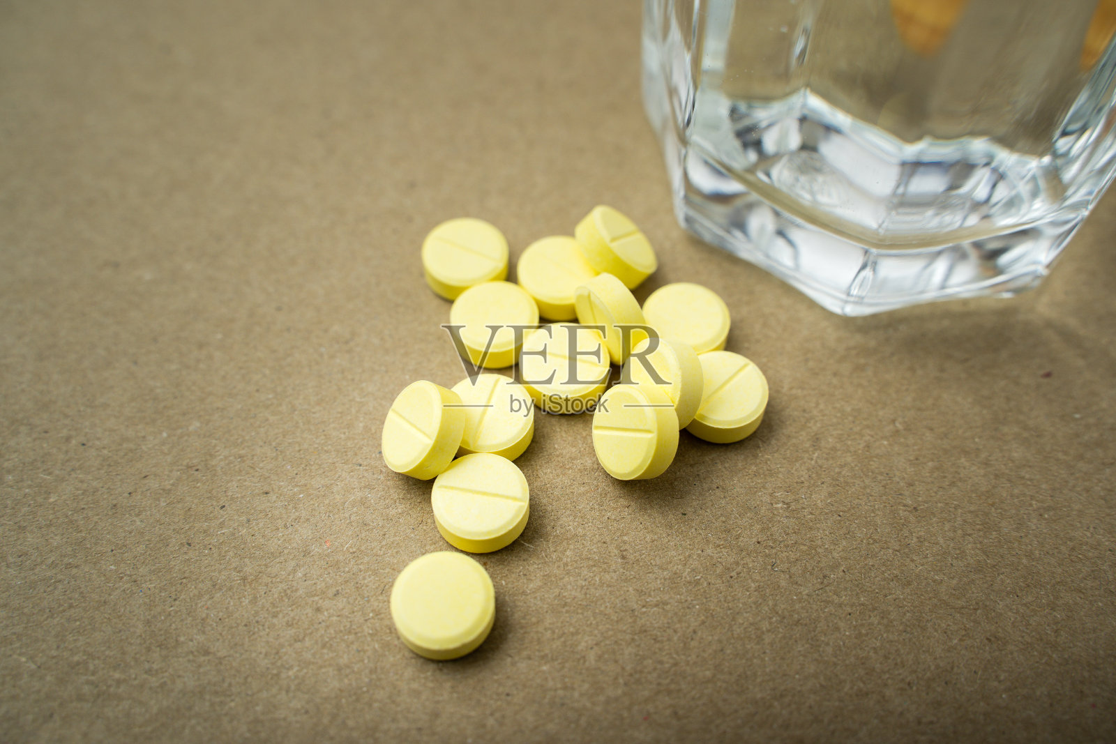 医药药丸和棕色底色加水的玻璃杯。照片摄影图片