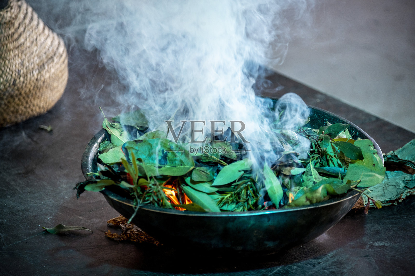 土著吸烟仪式。碗和木头，火和烟和口香糖树叶..照片摄影图片