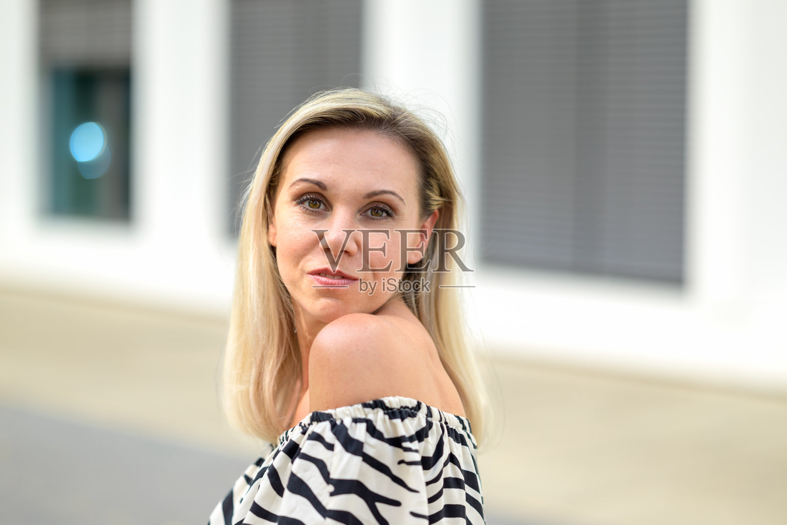 漂亮的中年金发女人微笑着转向镜头照片摄影图片