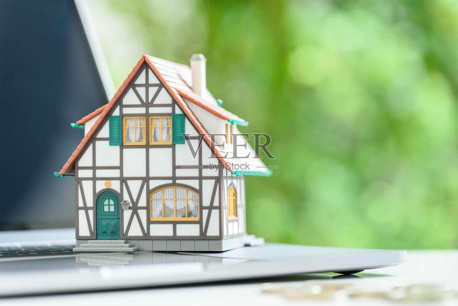 在线房屋拍卖，在线房产估价和纳税，金融概念:模型半木材，两层的房子在笔记本电脑键盘上。照片摄影图片