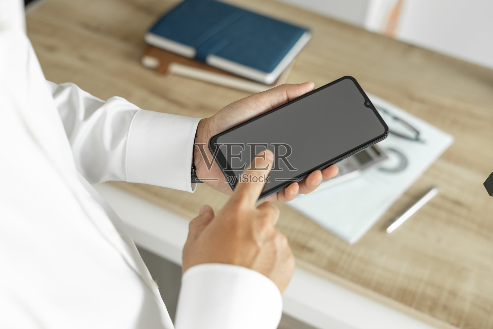 商人用电话沟通商业投资，男人穿着白衬衫站在办公室照片摄影图片