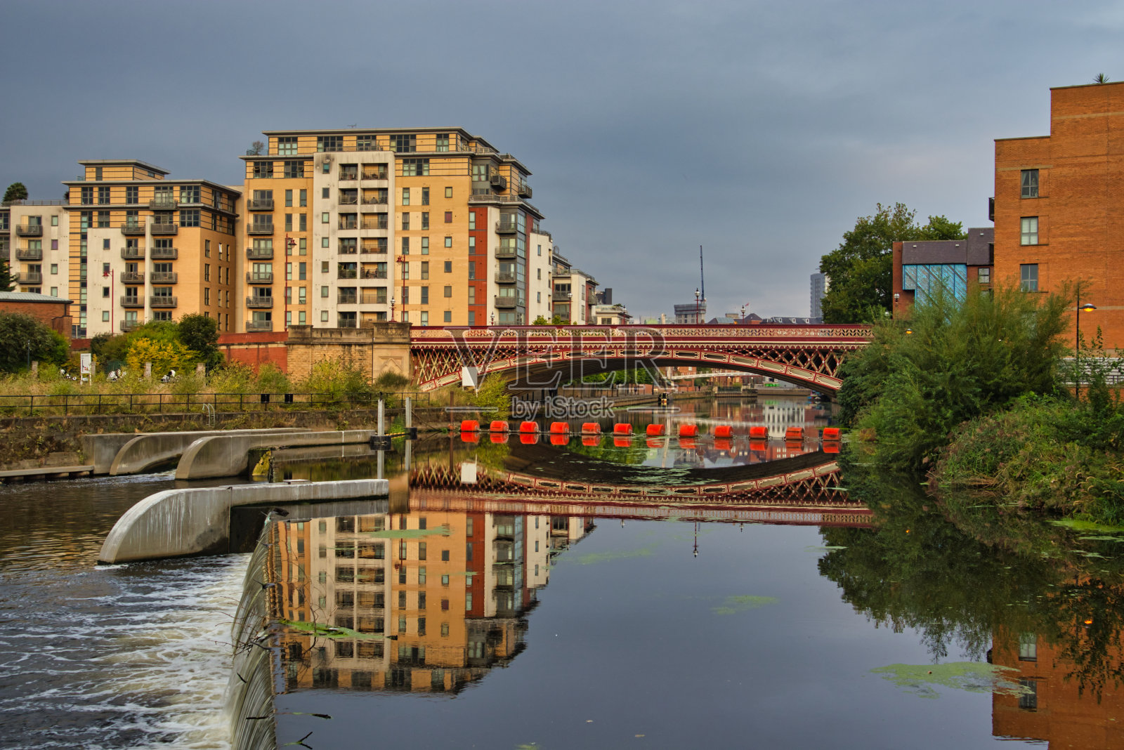 现代公寓大楼和皇冠点桥反映在河Aire，利兹，西约克郡，英国照片摄影图片