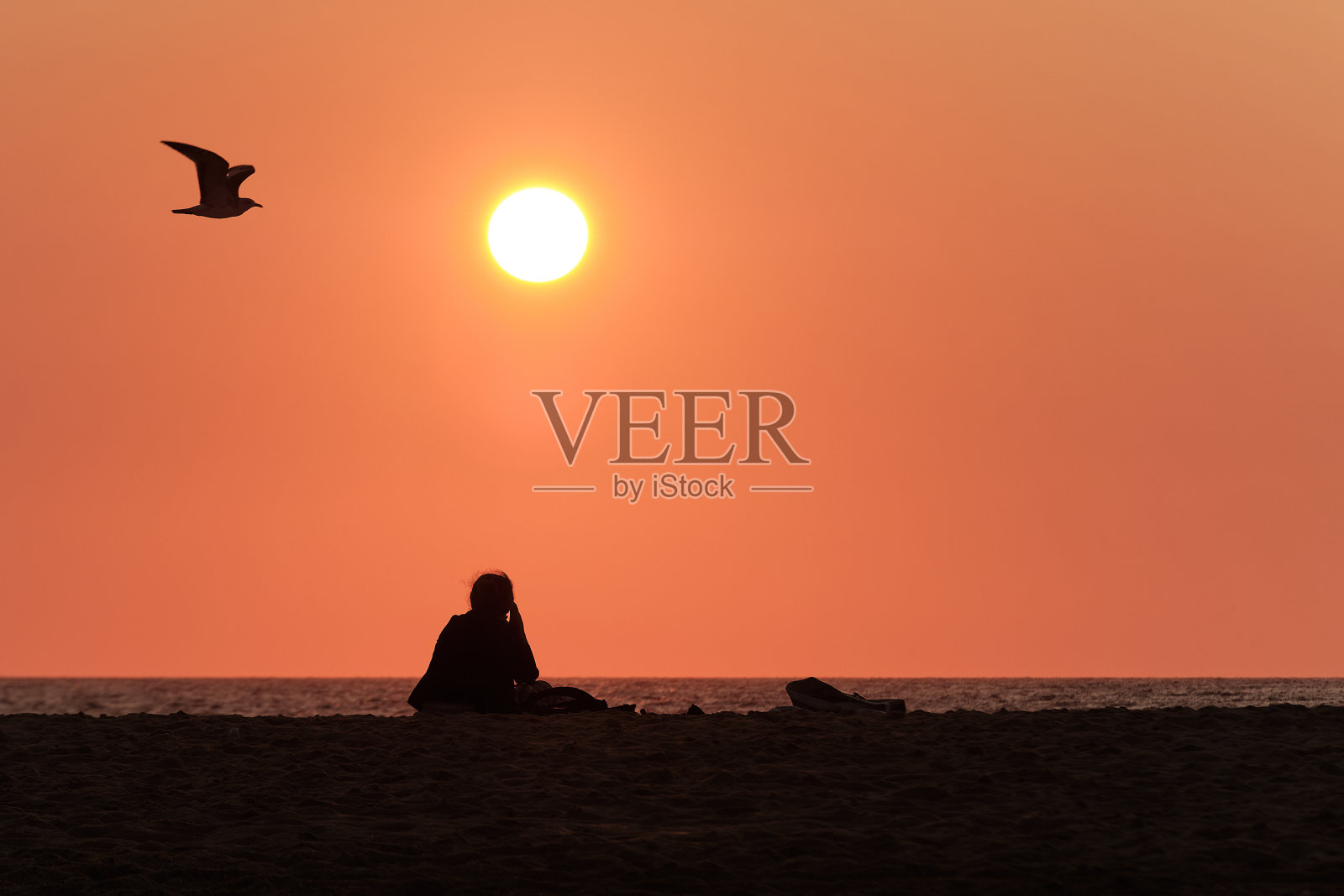 一个陌生的女人看着夏天的日落照片摄影图片