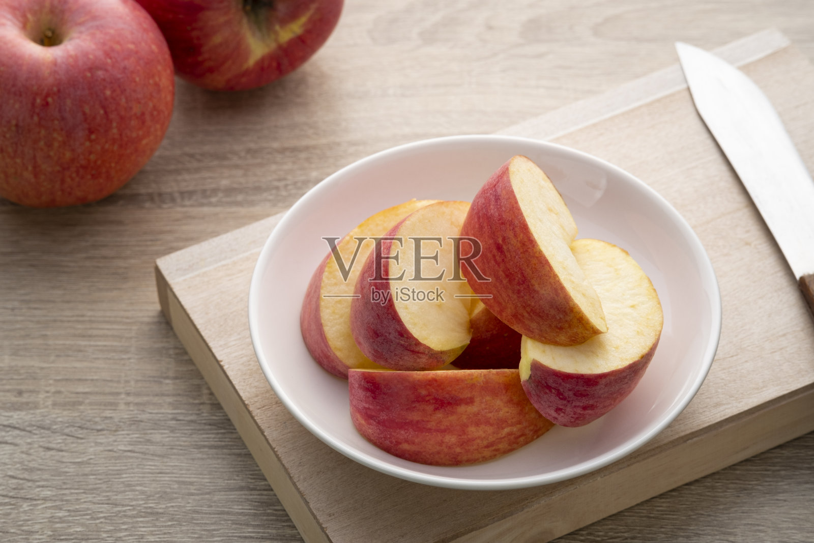 新鲜的红苹果切成片放在白色的盘子里照片摄影图片