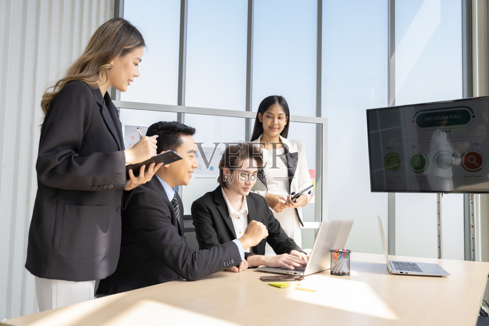 一群年轻的亚洲商人愉快地谈论和规划工作，玩得很开心。在公司的办公室照片摄影图片