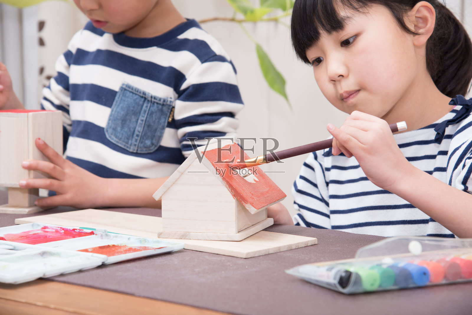 日本小学生用颜料给作品上色照片摄影图片