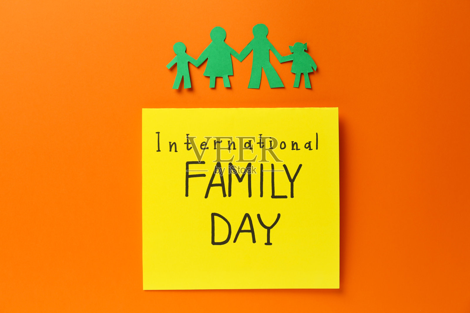 纸剪纸和卡片与文字国际家庭日在橙色的背景，平lay照片摄影图片