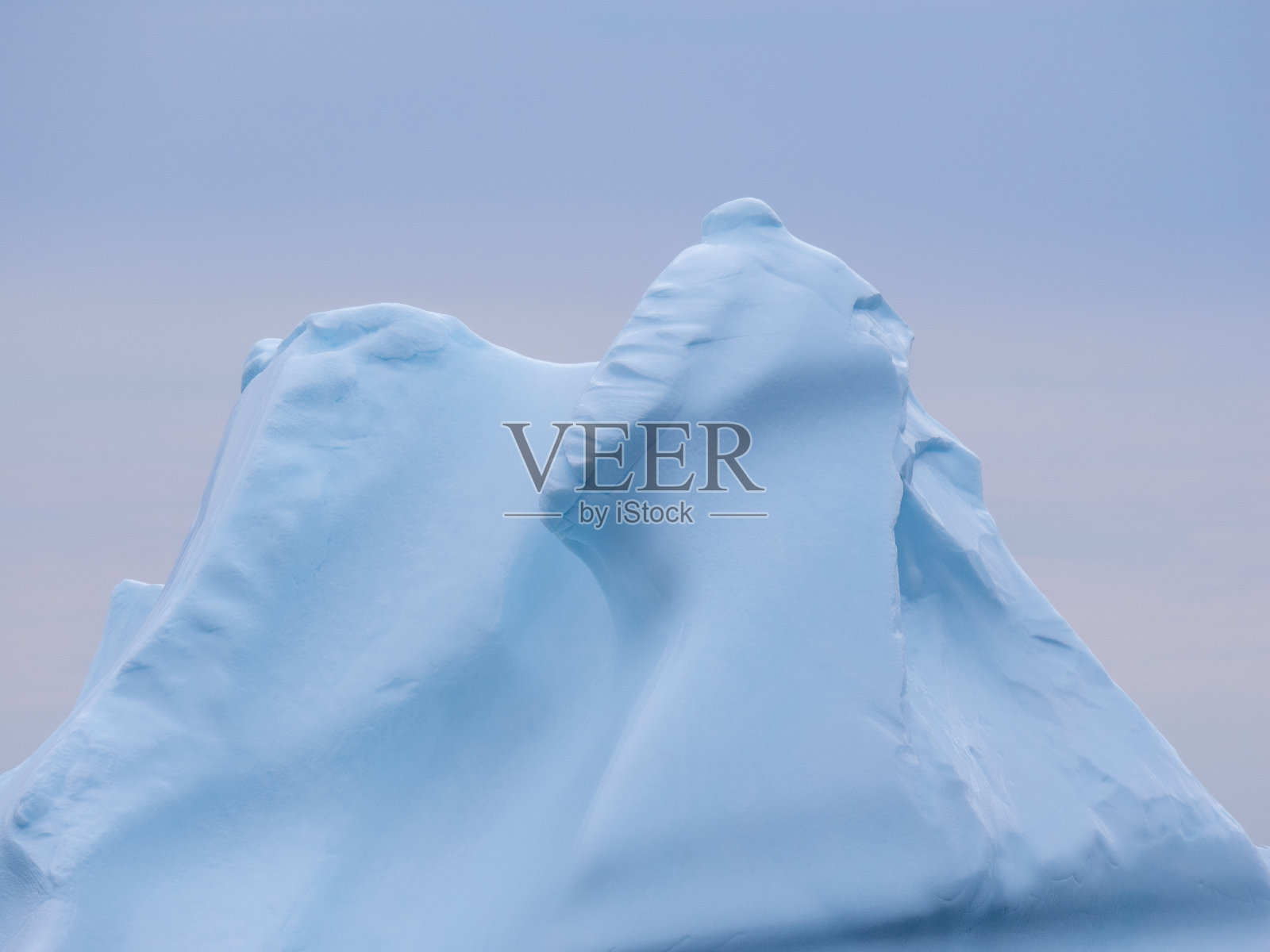 在午夜的阳光下，在格陵兰岛西海岸的巨大冰山之间航行照片摄影图片