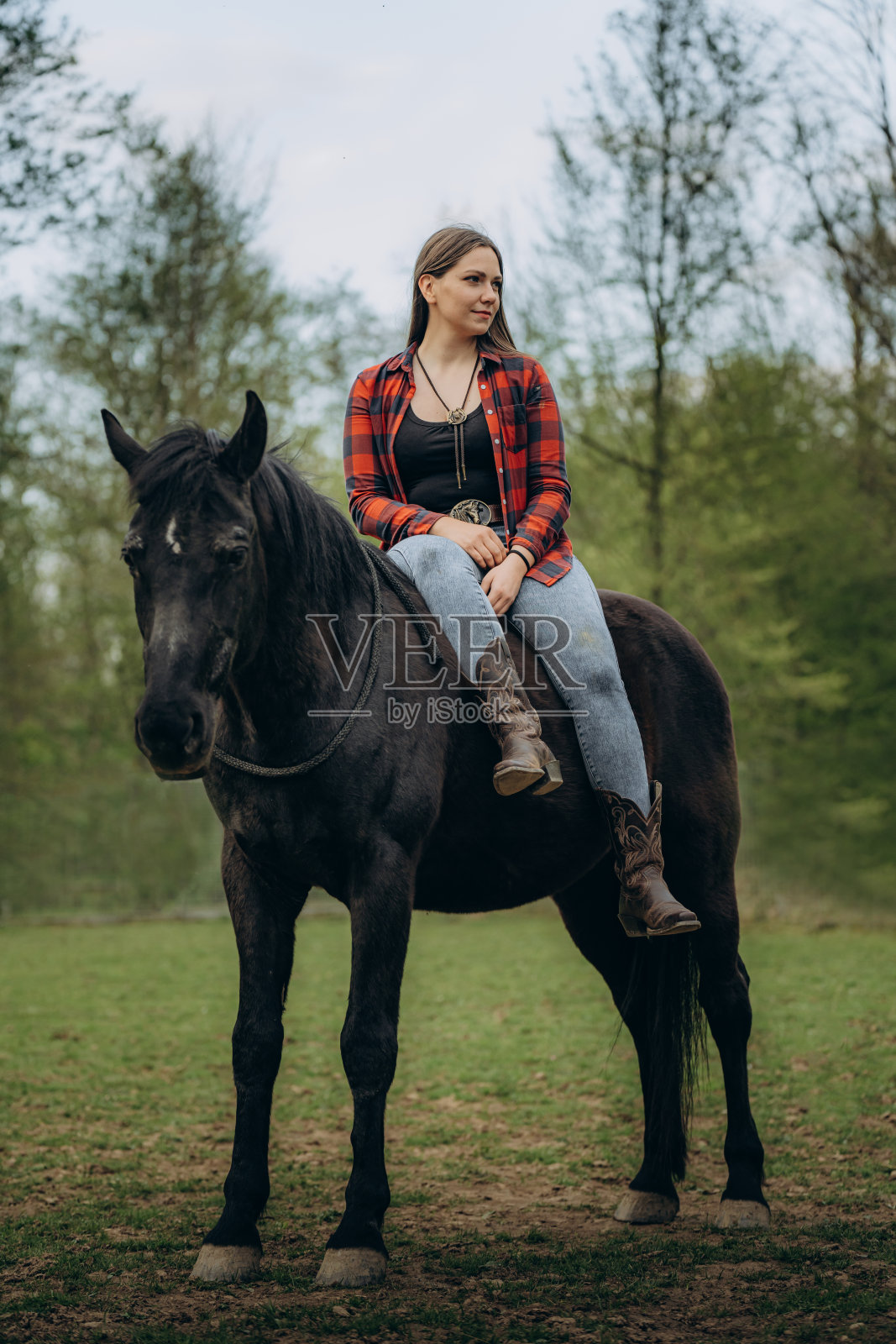 有思想的年轻女子在牧场骑马照片摄影图片