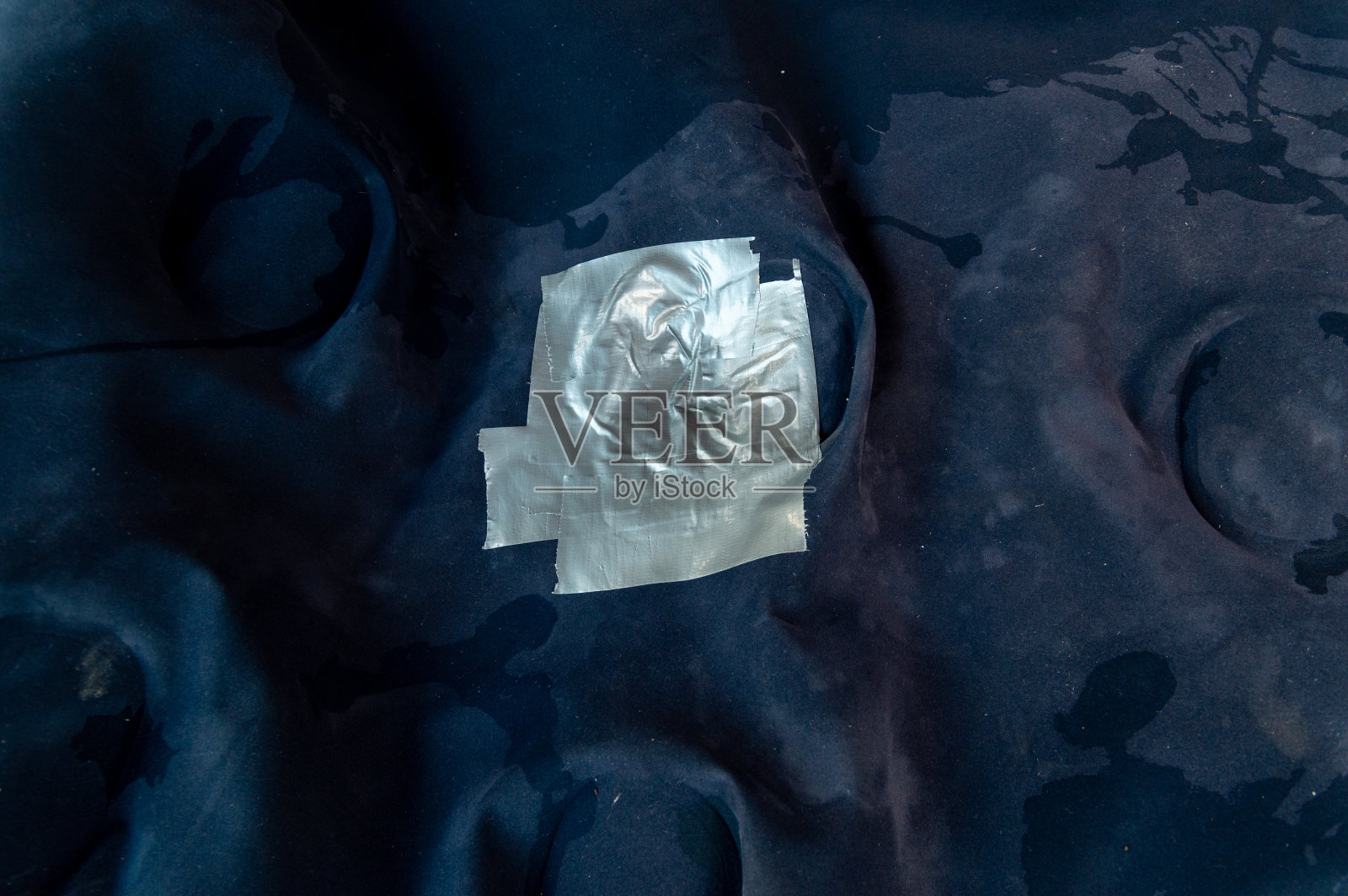 用灰色胶带粘在气垫上的洞照片摄影图片