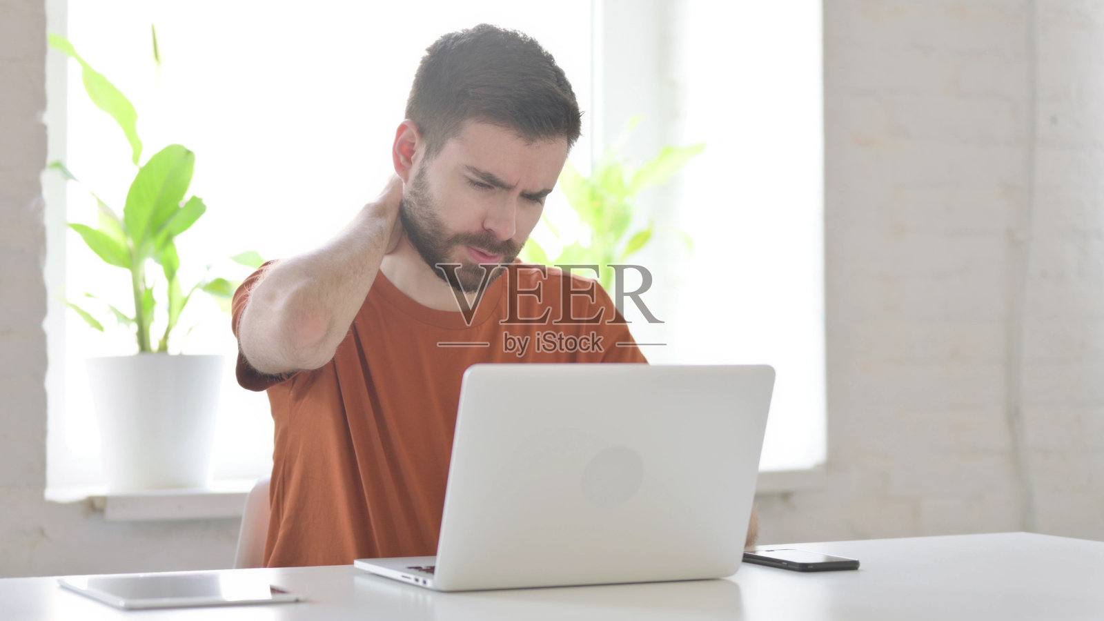 工作中颈部疼痛的年轻人照片摄影图片