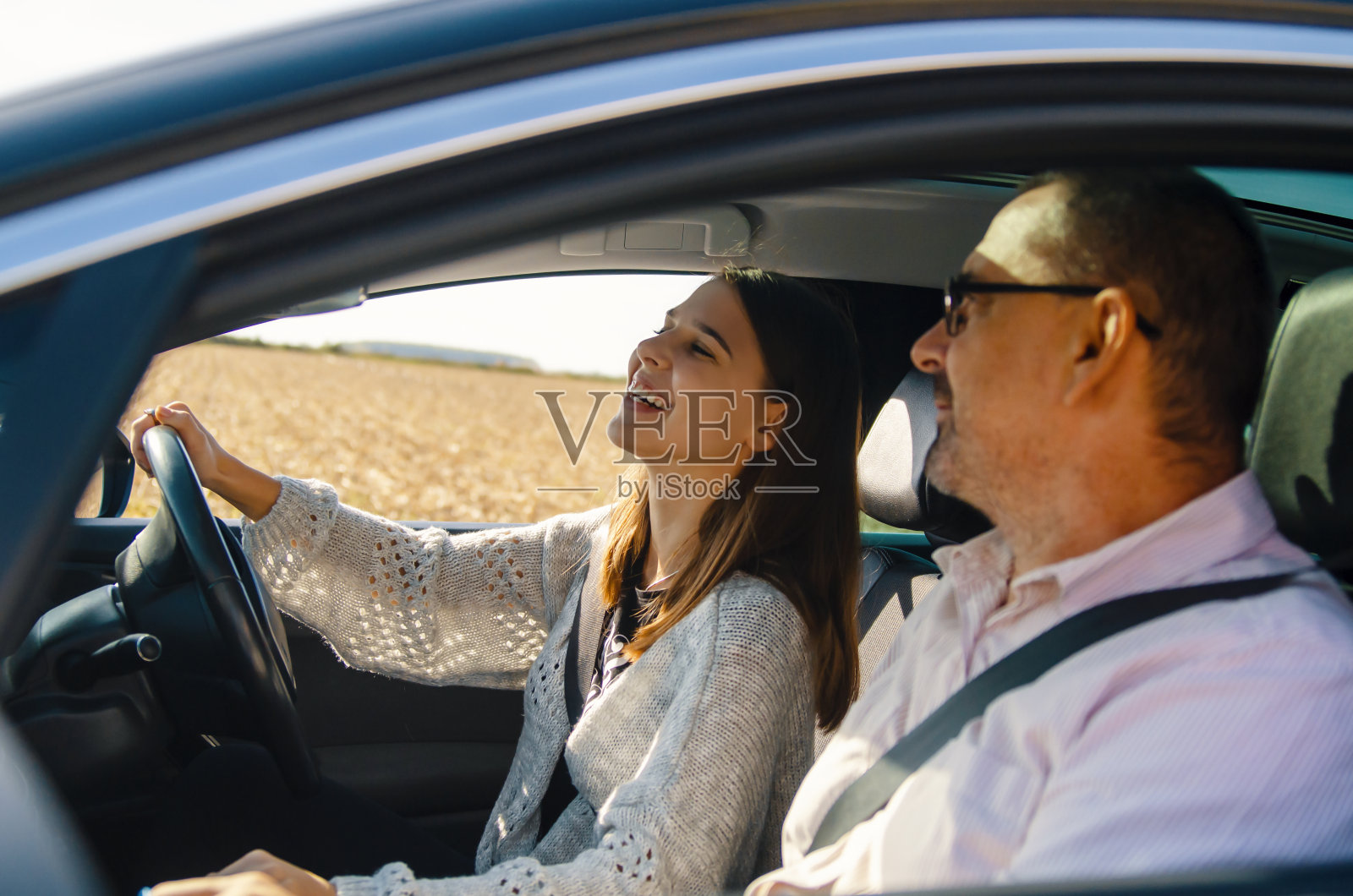 十几岁的女孩开车送她爸爸照片摄影图片