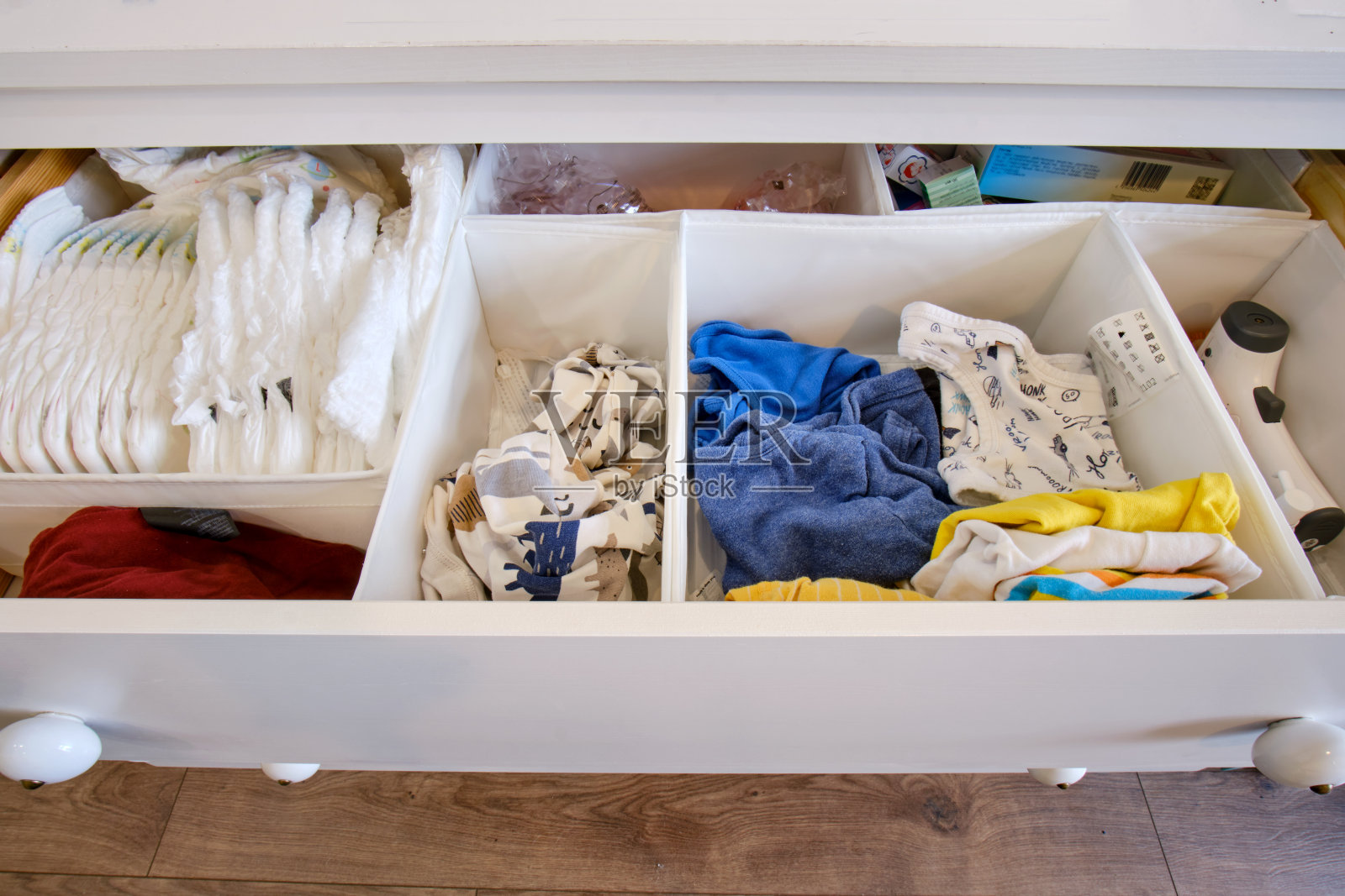 存放儿童衣物的白色衣柜抽屉，开放的衣柜货架近距离与衣物照片摄影图片