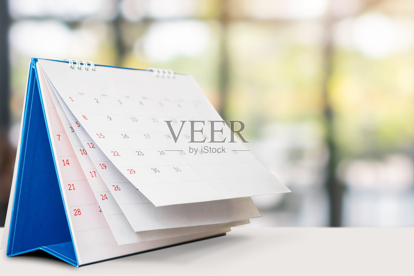 桌上的台历与模糊的散景背景约会和商务会议的概念照片摄影图片